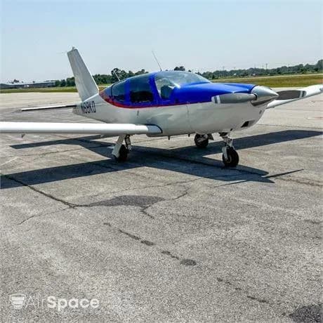 A white and blue single-engine propeller aircraft with registration N68KD on a tarmac under a clear sky.