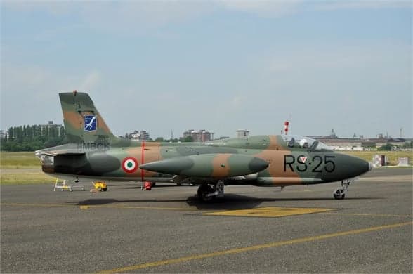 Camouflaged aircraft I-MBCK on the runway with landing gear down.