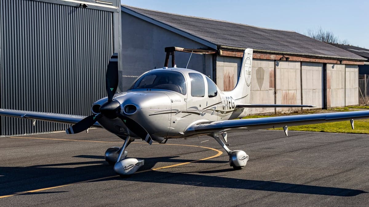 Front view of the silver Cirrus OY-TEG on the tarmac.