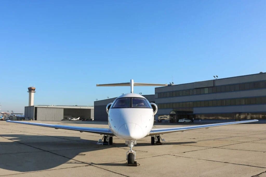 Front view of the Pilatus PC-24 N357LT parked on the tarmac in front of a building.