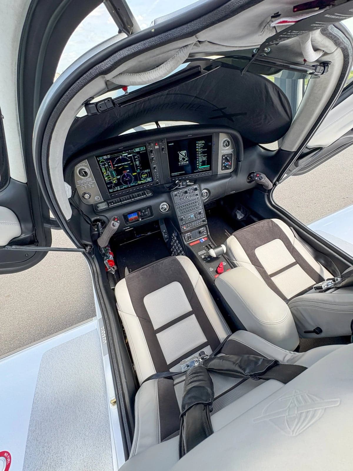 View of the Cirrus SR22T cockpit with modern avionics and gray seats.