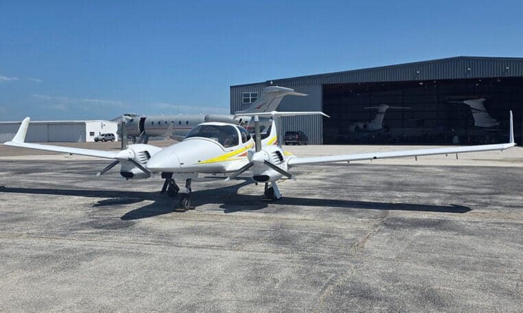 Diamond DA62 aircraft parked on the tarmac in front of a hangar.