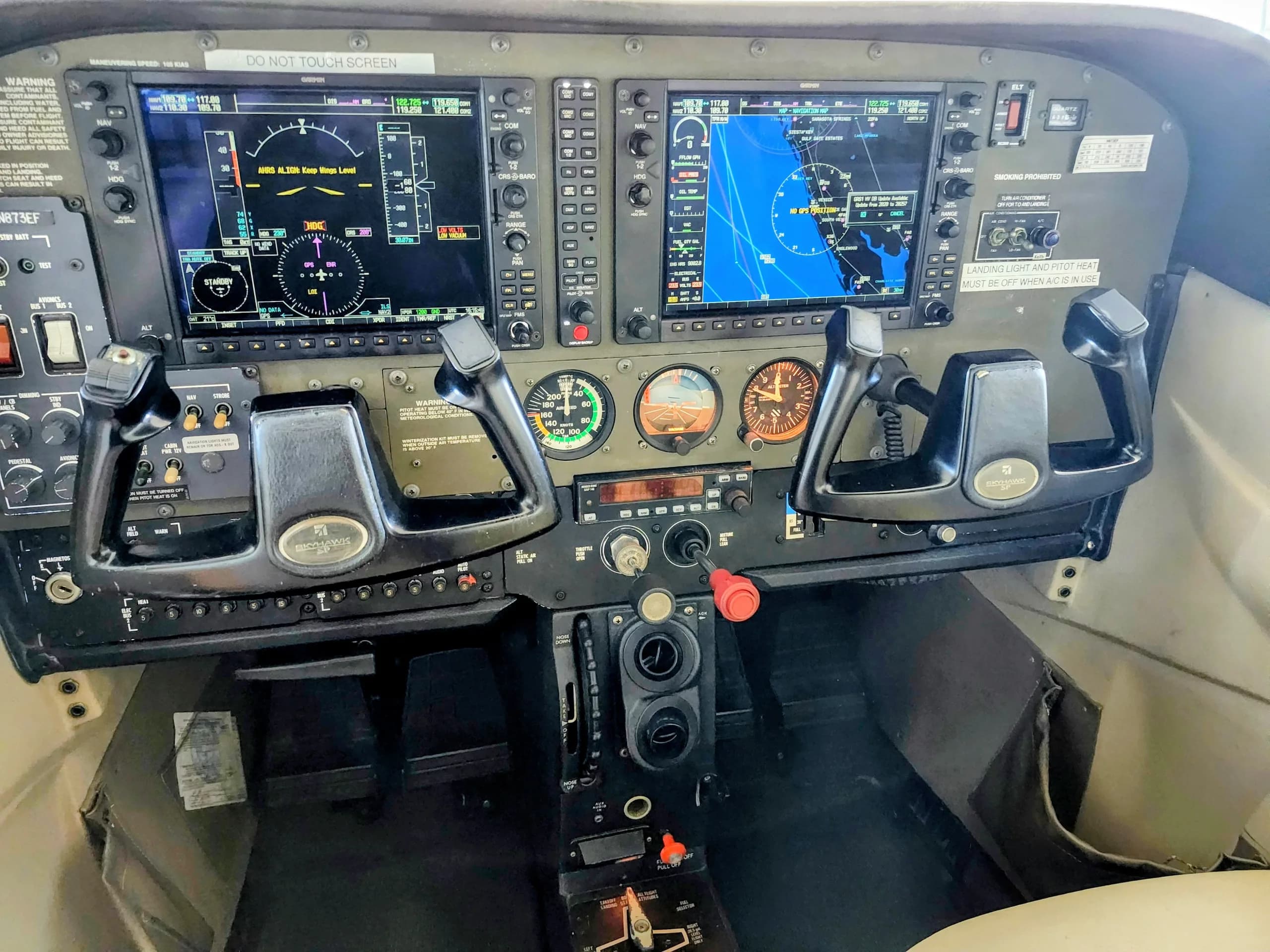 A wide view of the aircraft's cockpit featuring dual yoke controls and digital displays.