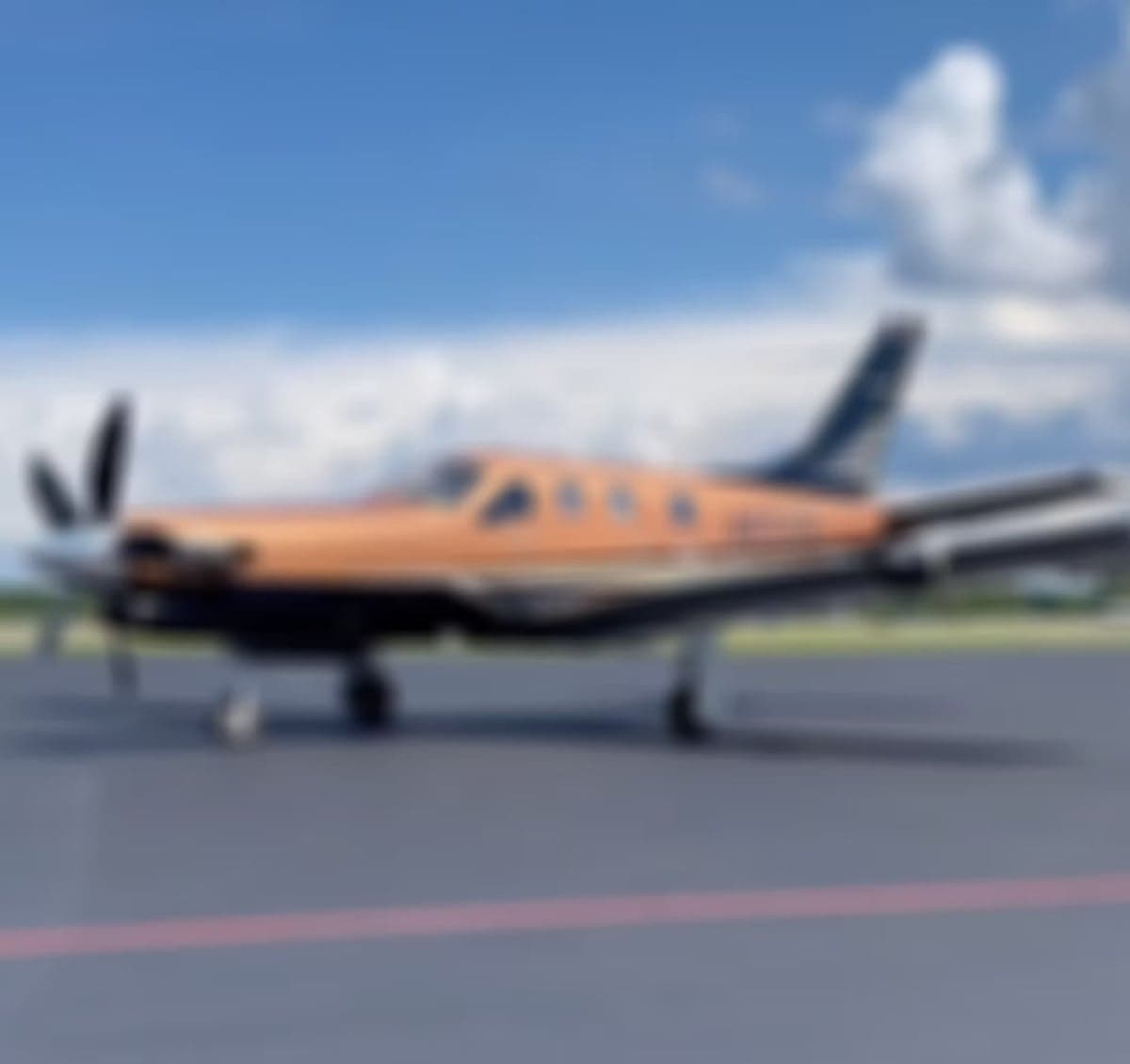 Blurred image of Pilatus PC-12 aircraft N970TB on the tarmac.