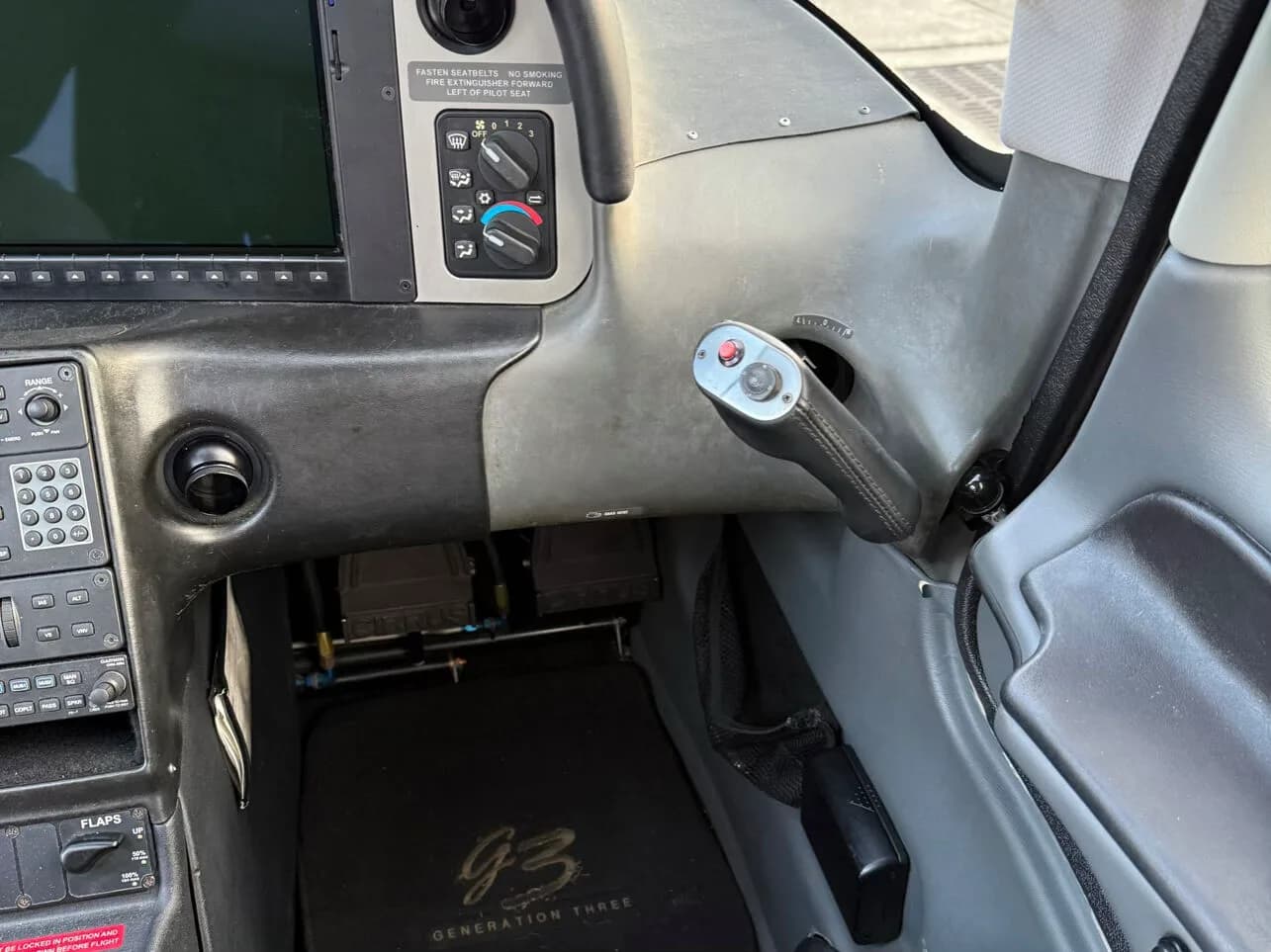 A close-up view of the right side of a Cirrus SR22 cockpit, showing the side yoke and environmental controls.