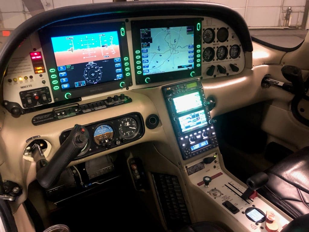 The cockpit of the aircraft features a modern glass panel display and beige interior.