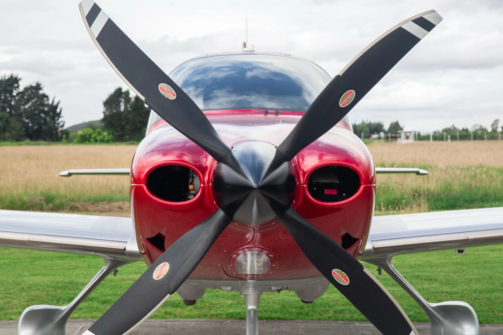Frontal close-up of the black propeller and red nose of the Cirrus SR22T aircraft.