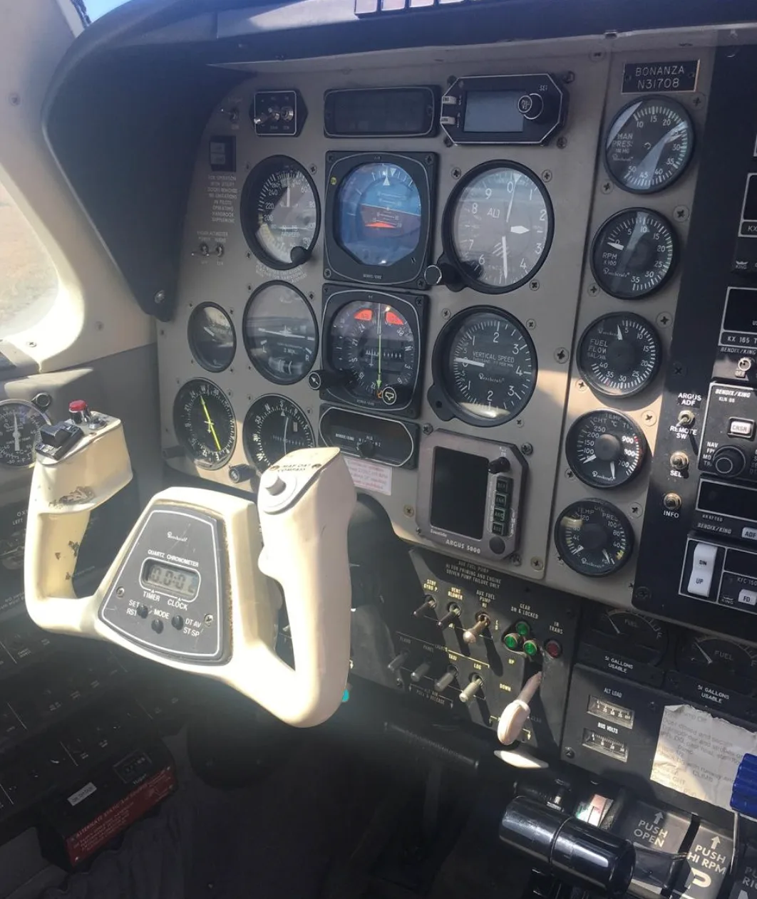 A close-up view of the instrument panel and pilot's control yoke in a Beechcraft Bonanza.