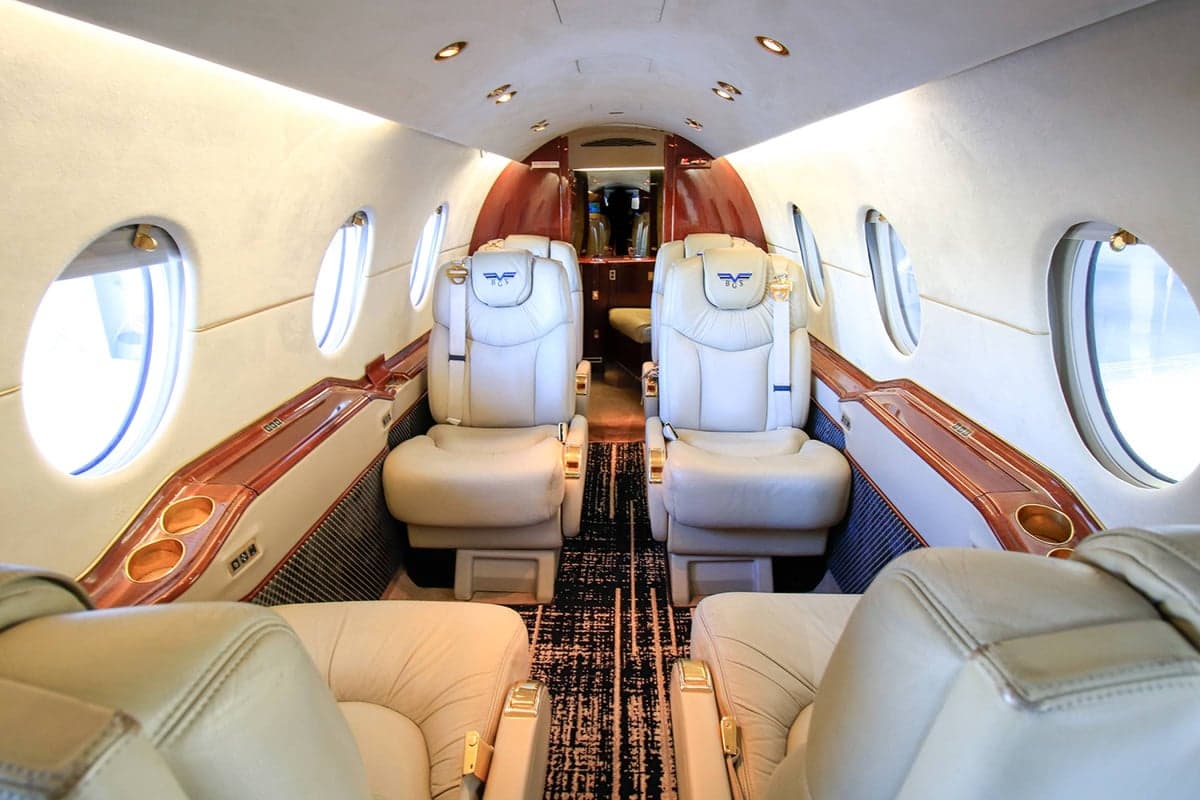 View of the Beechjet 400A cabin with tan leather seats and wood trim.