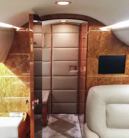 Aircraft interior with wood paneling and a door.