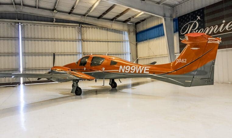A Diamond DA62 aircraft with registration N99WE is parked in a hangar.