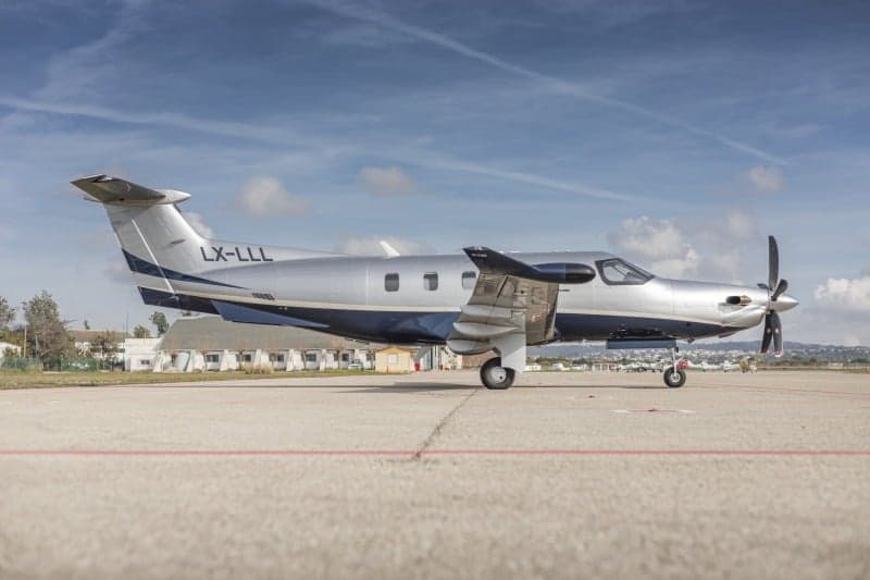A Pilatus PC-12 aircraft with registration LX-LLL parked on the tarmac.
