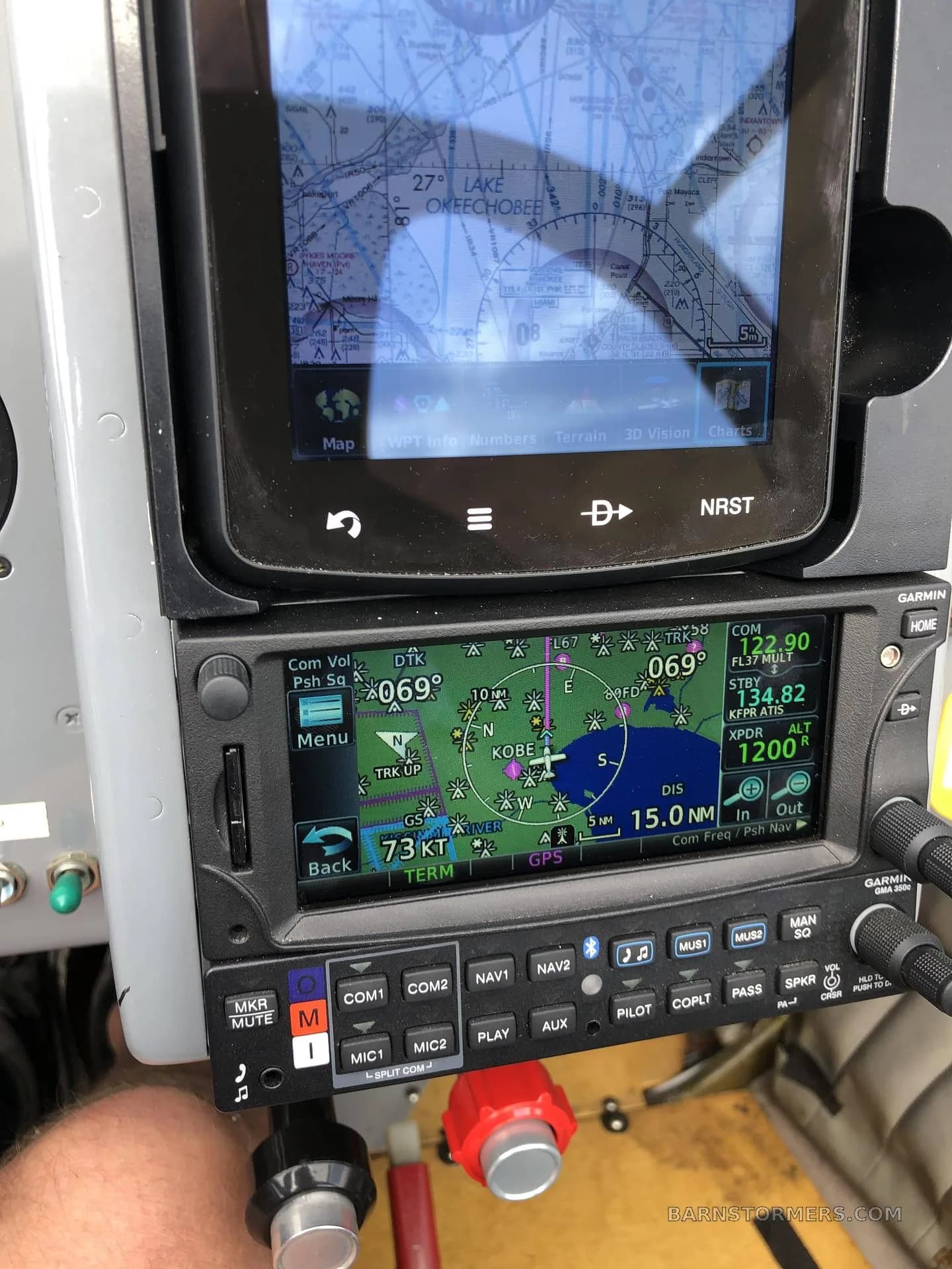 A close-up view of an aircraft's cockpit showing two Garmin navigation and communication displays with a map of Lake Okeechobee.