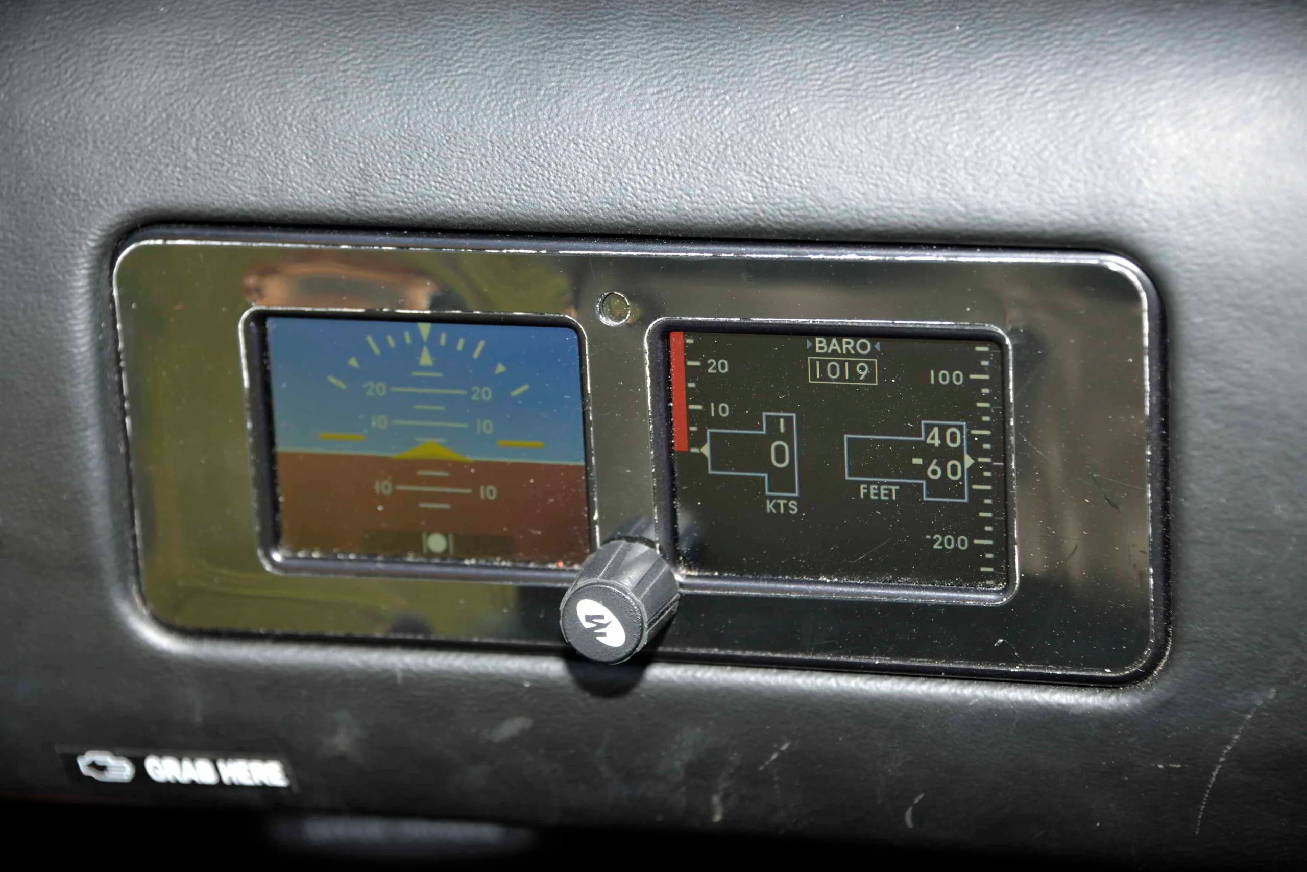 A close-up of small digital gauges in the cockpit displaying attitude, altitude, and airspeed.