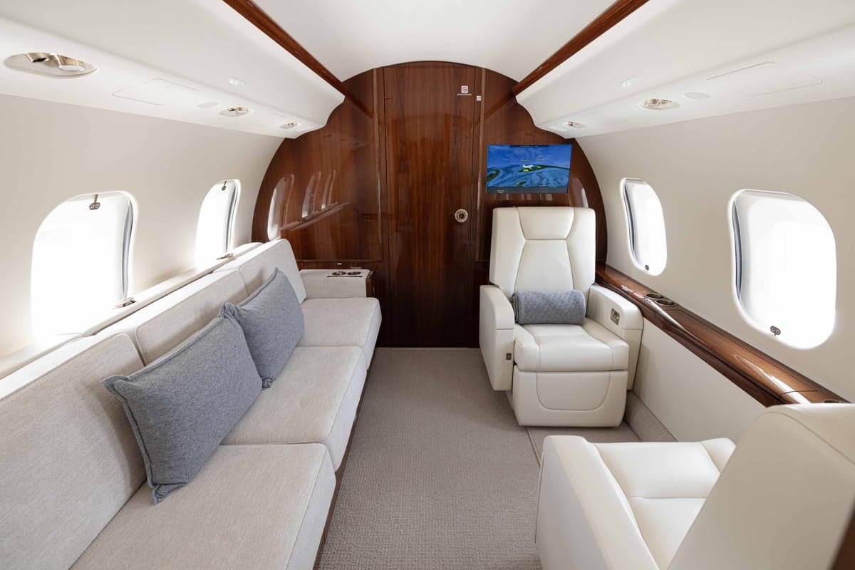 View of the aircraft interior with a sofa and single seats.