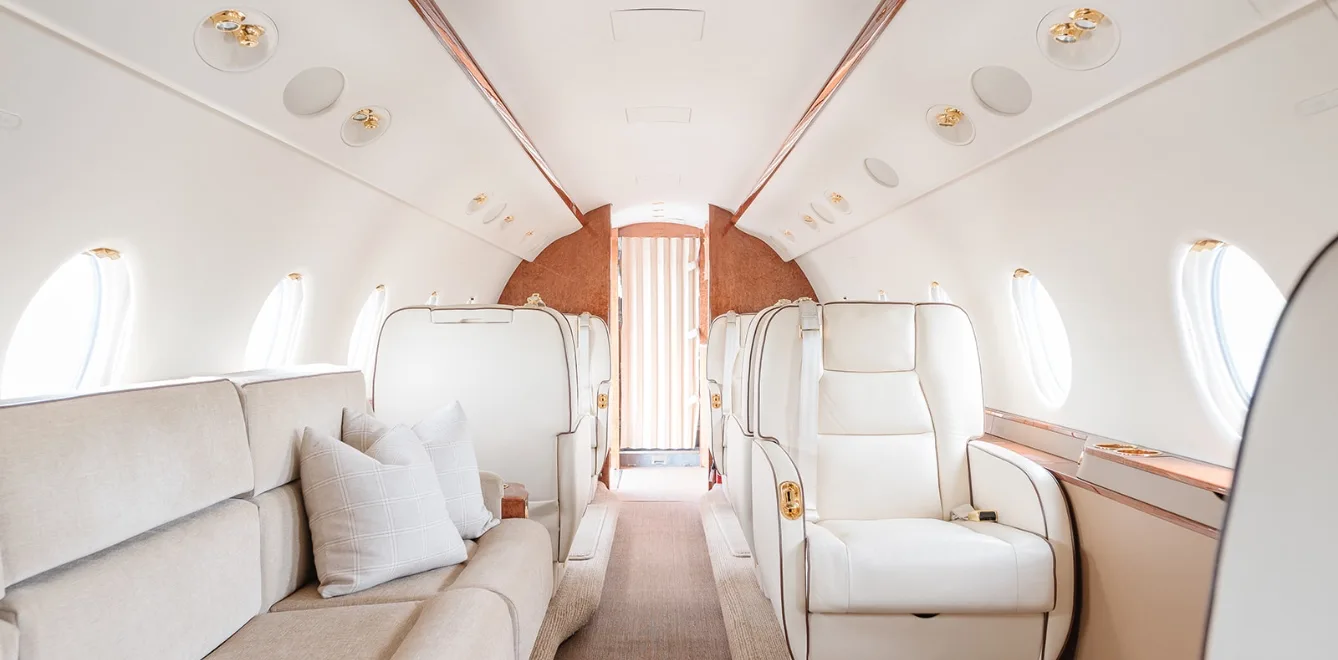View of the aircraft interior with beige seats and wood accents.