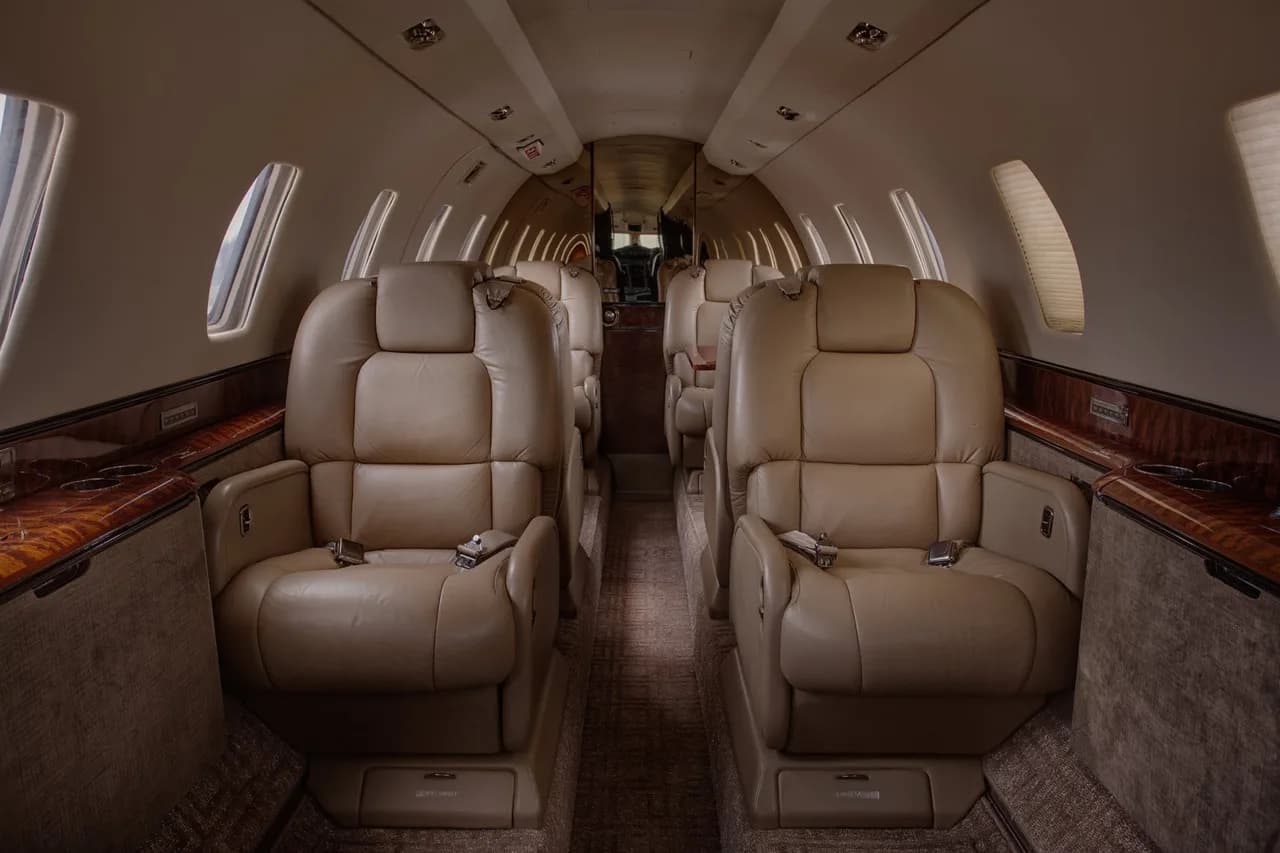 Aircraft interior with leather seats and wood accents.