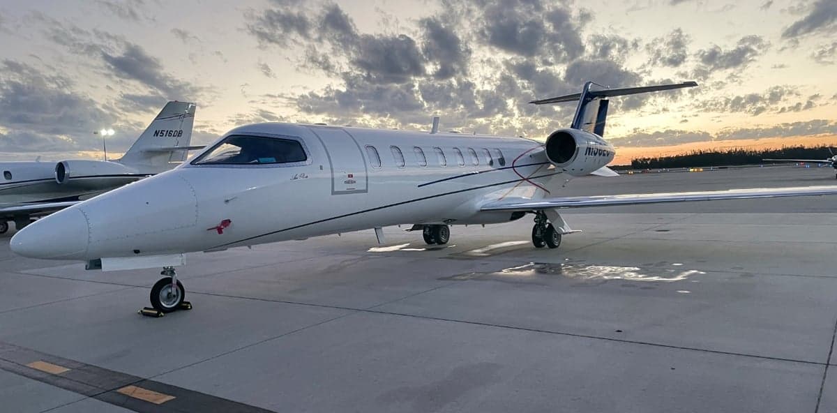 Learjet aircraft on the tarmac at sunset.