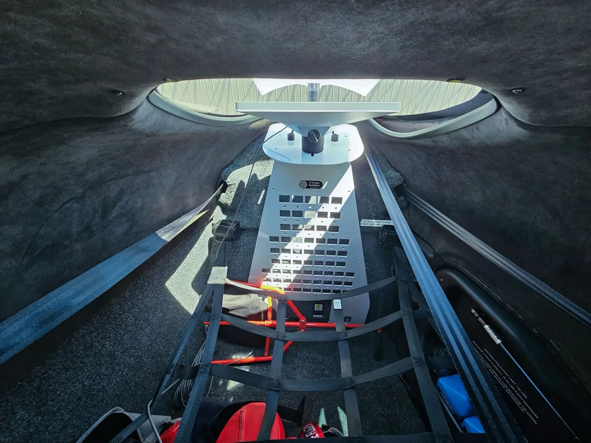 The baggage compartment of the Cirrus SR22T, showing a cargo net and a gray equipment panel.