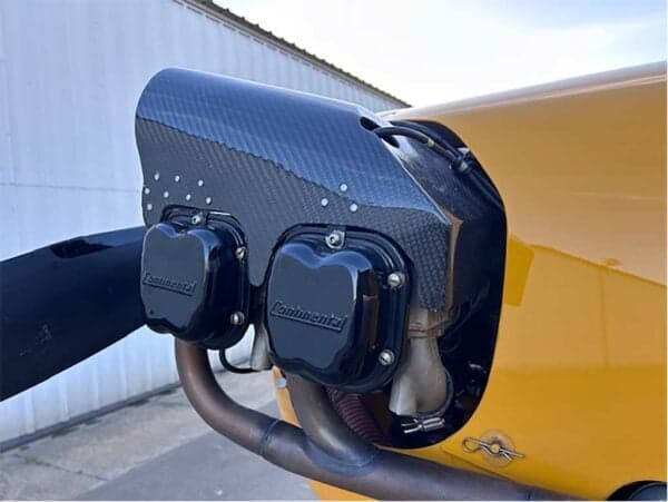 Detailed view of the Continental engine and propeller of a yellow Legend Cub aircraft.