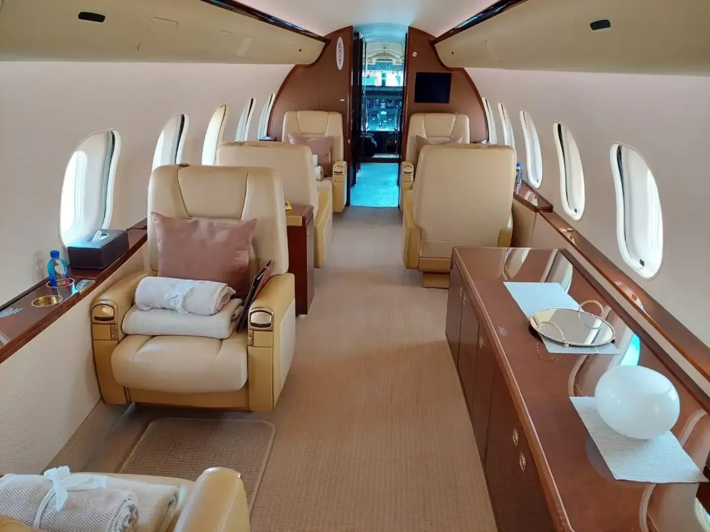 The interior of a Bombardier Global Express business jet showing the seating arrangement and amenities.