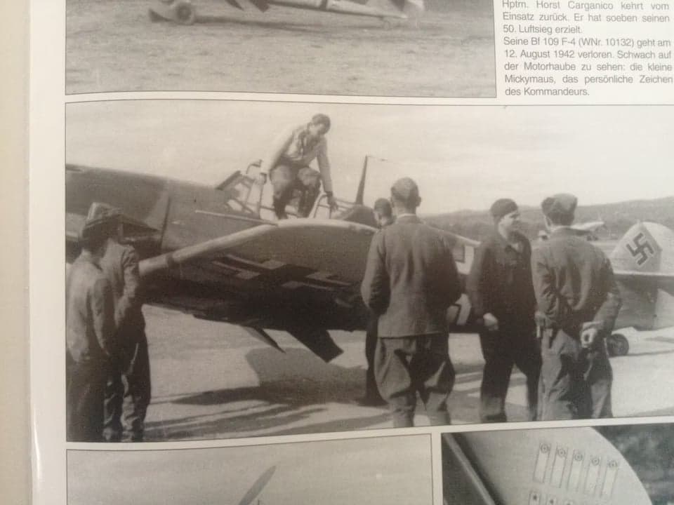 A Bf 109 F-4 aircraft with a pilot climbing into the cockpit.