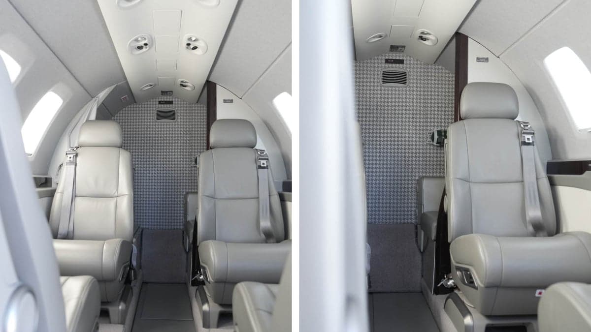 The aircraft's cabin features gray leather seats and overhead lighting.
