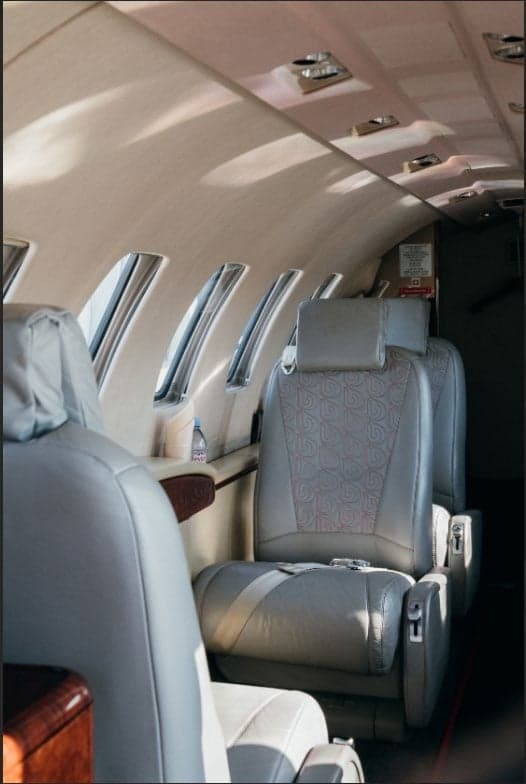 Aircraft interior featuring leather seats and cabin windows.