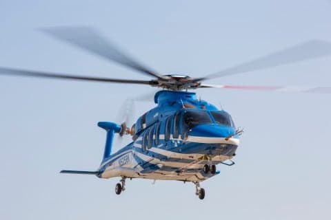 A blue and white Bell 525 helicopter in flight.