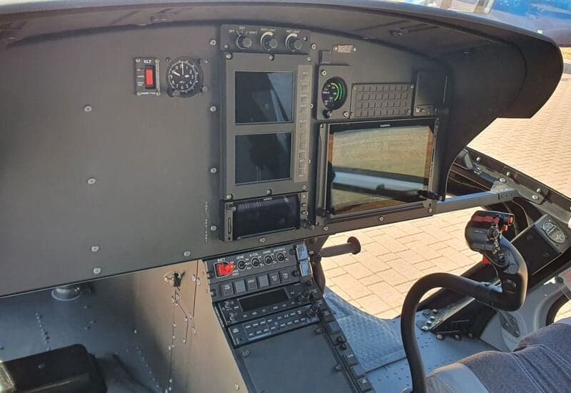 A view of the instrument panel and controls in the cockpit of a helicopter.
