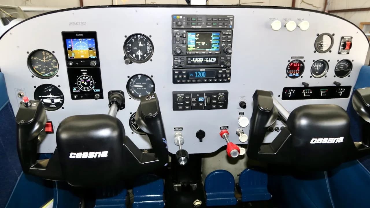 The cockpit of a Cessna 172, N8462X, showing the instrument panel with modern avionics and two control yokes.