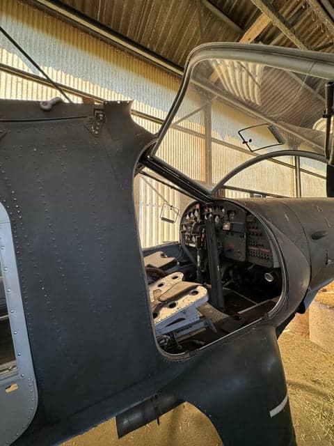 Side view of the HB-HAB aircraft cockpit and nose inside a hangar.
