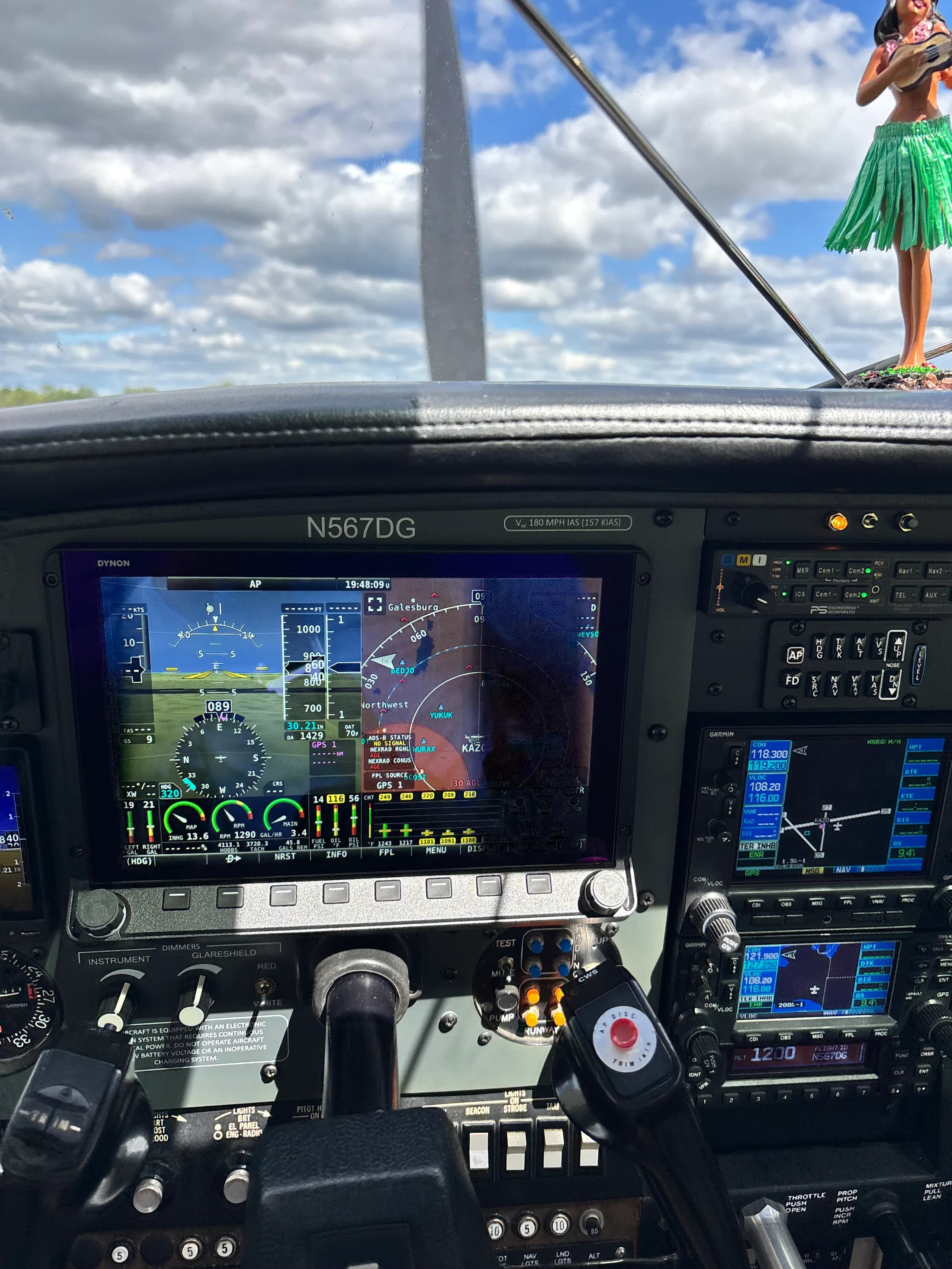 A close-up view of an aircraft's modern glass cockpit display showing flight information, with N567DG visible on the panel.