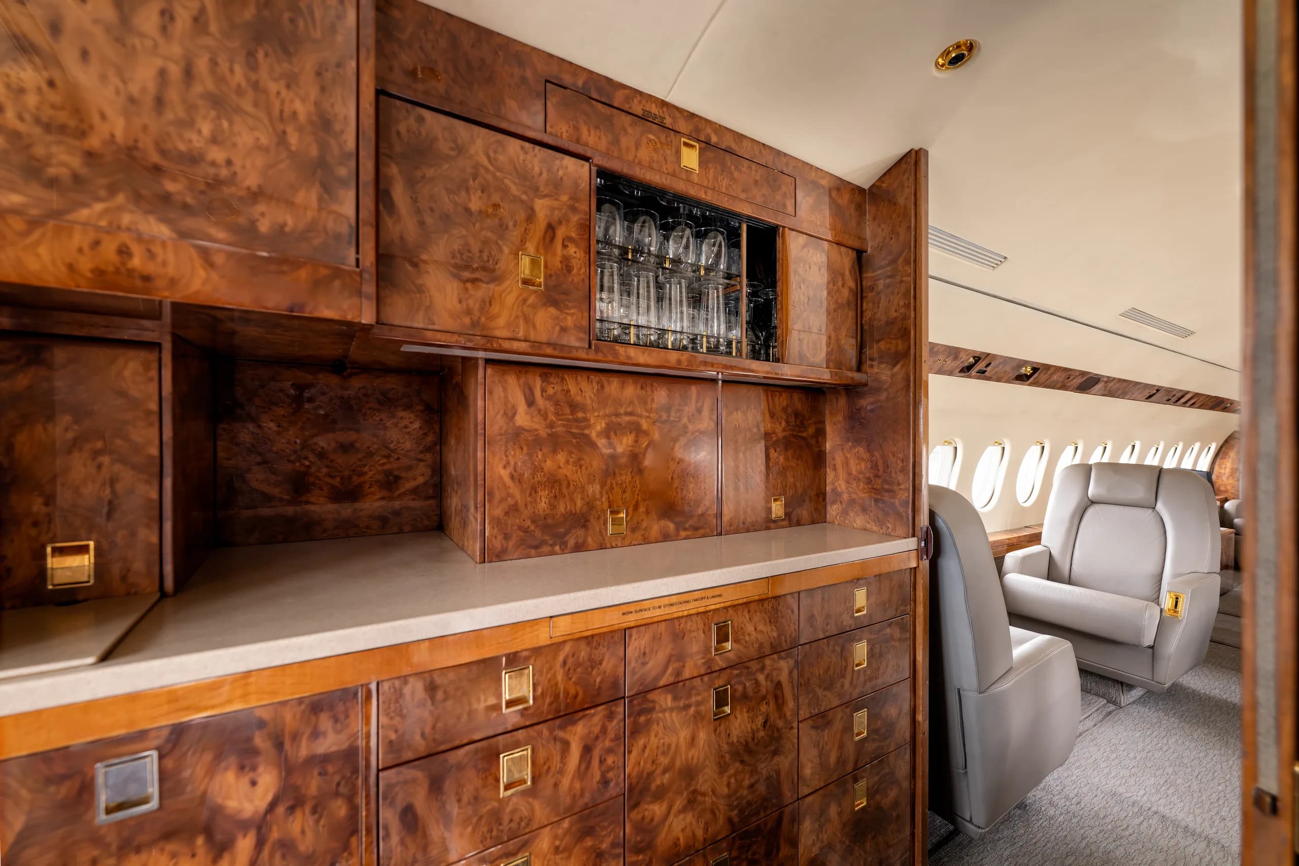 View of the aircraft interior with wood cabinets and leather seats.