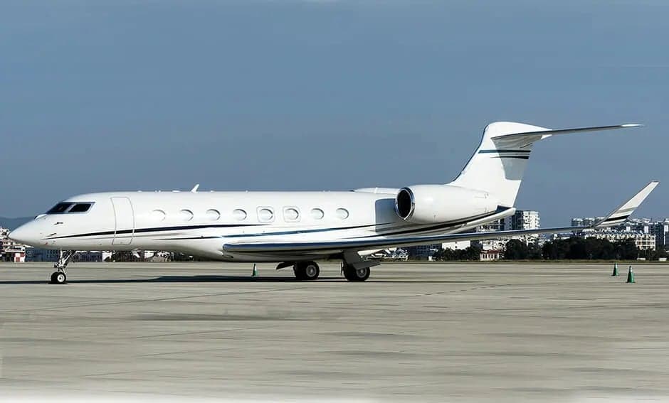 A white private jet sits on the tarmac.