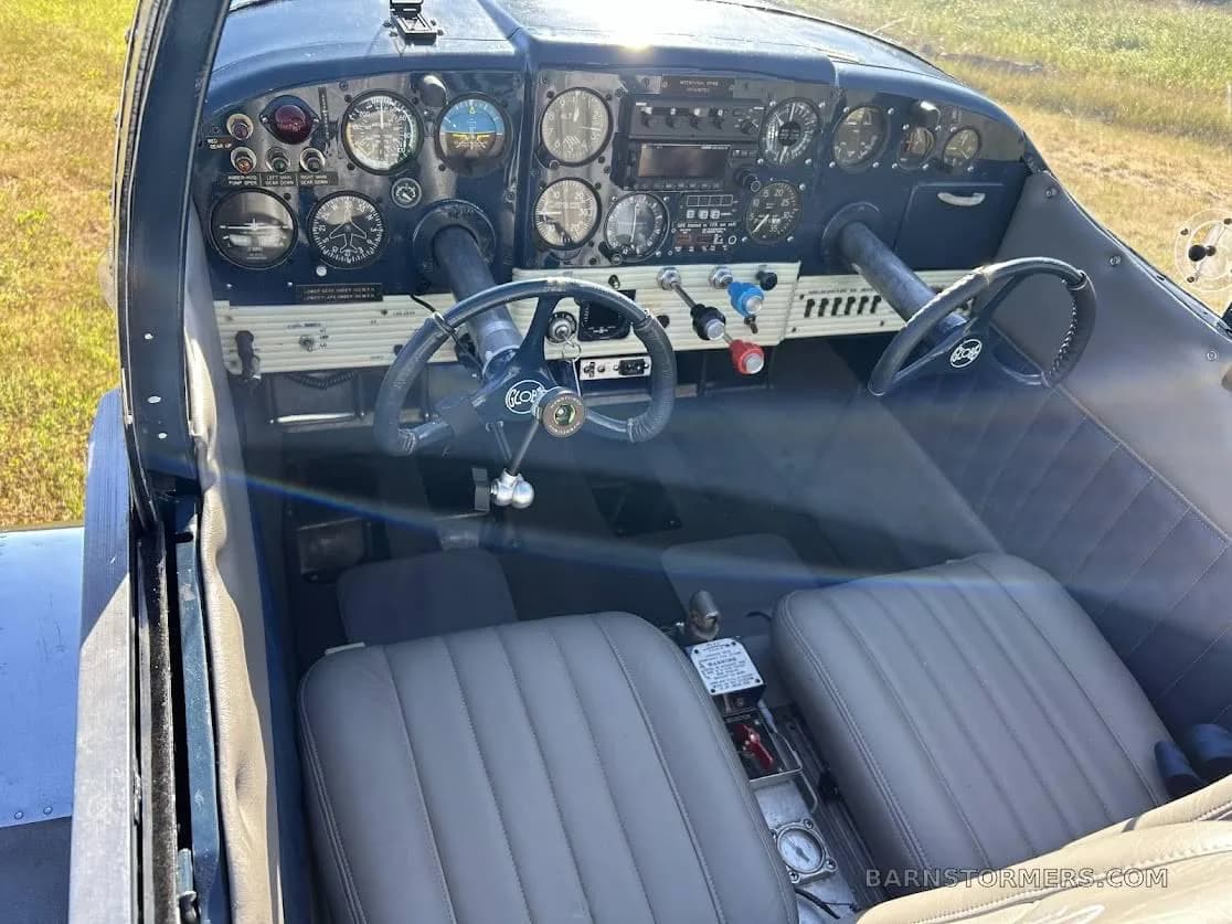 The cockpit of the aircraft, featuring a dark instrument panel with multiple gauges and two control yokes.