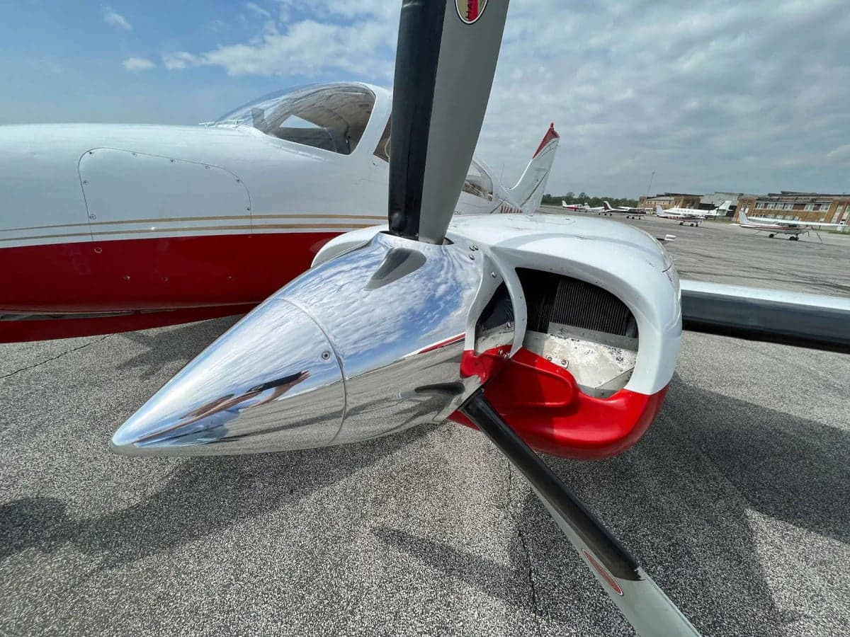 A close-up view of the polished propeller spinner and engine cowling of the N1242G aircraft.