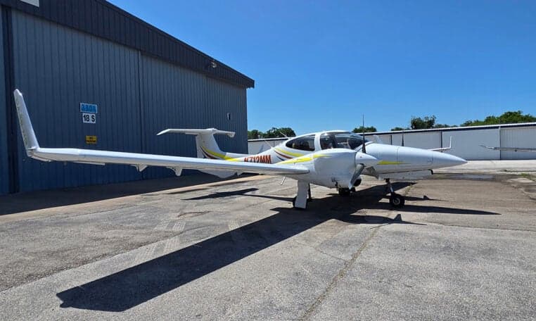 Diamond DA62 aircraft parked on the tarmac with a long shadow.