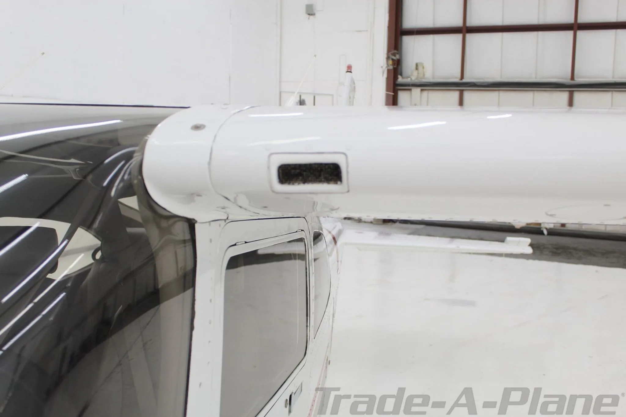 A close-up view of the wing root and top of the fuselage of the Cessna Skylane N6768R.