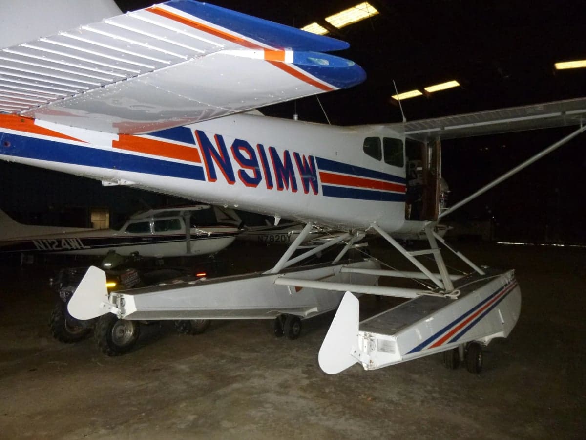 Cessna Skywagon 185 floatplane with registration N91MW in a hangar.