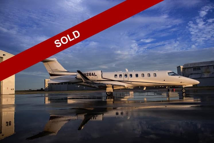 A Learjet 45XR aircraft with registration N26AL parked on the tarmac, with a SOLD banner overlay.