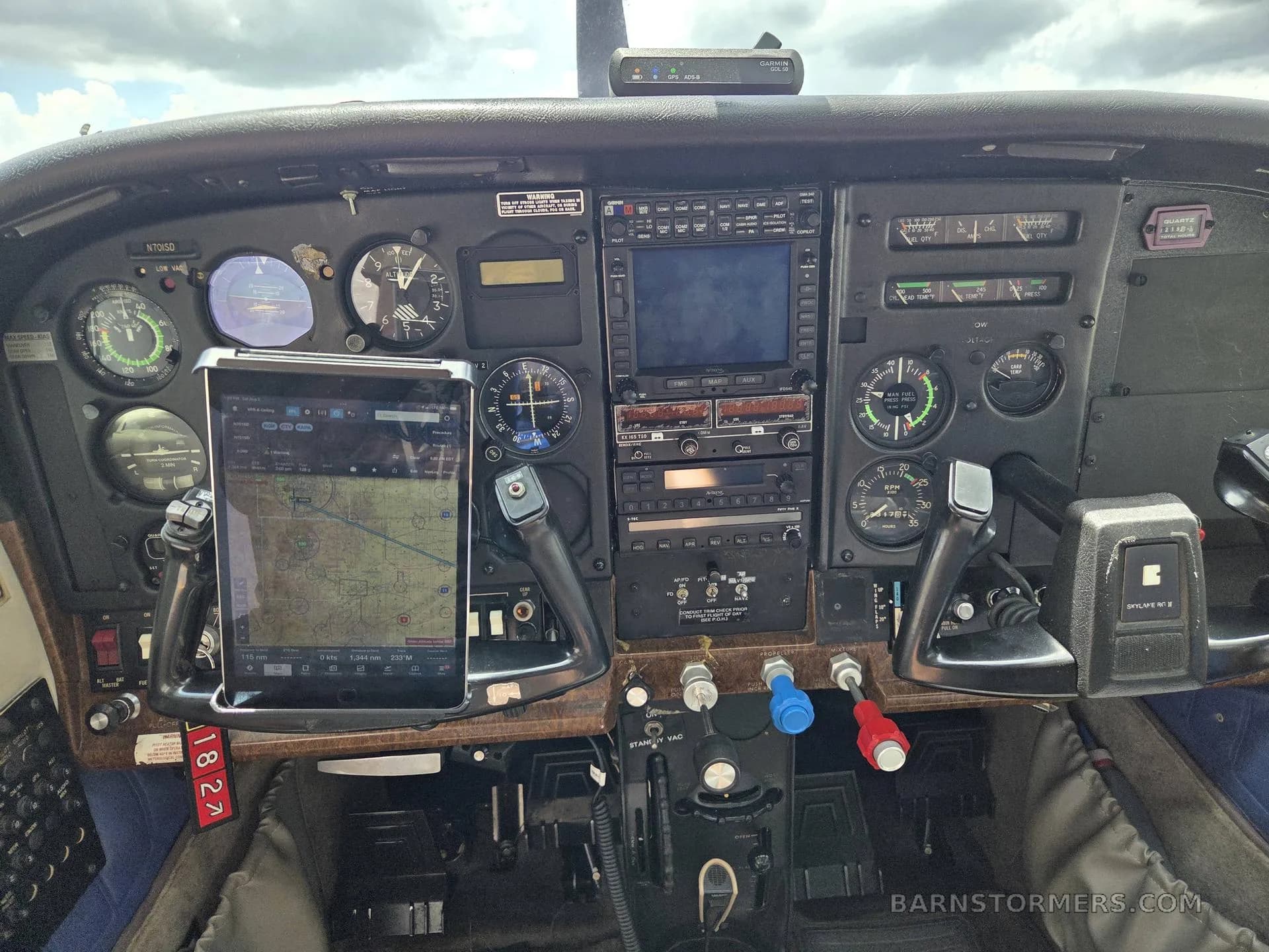 The cockpit instrument panel of a Cessna aircraft, featuring an iPad mounted on the yoke and various gauges and avionics.