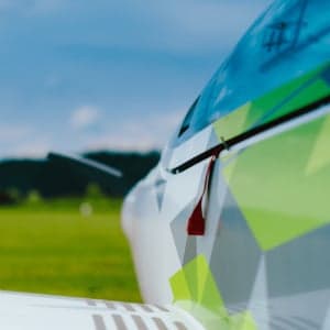 Close up of the tail of a white and green aircraft.