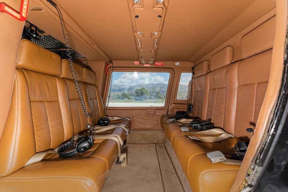 Interior view of the helicopter cabin with brown leather seats.