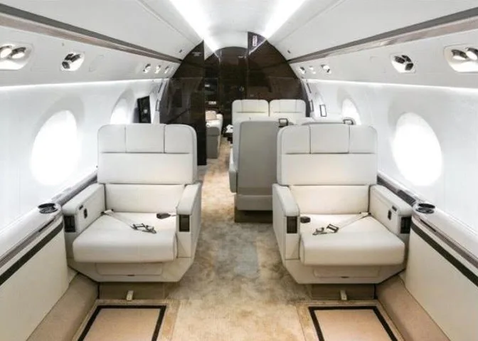 View of the aircraft cabin with white leather seats.