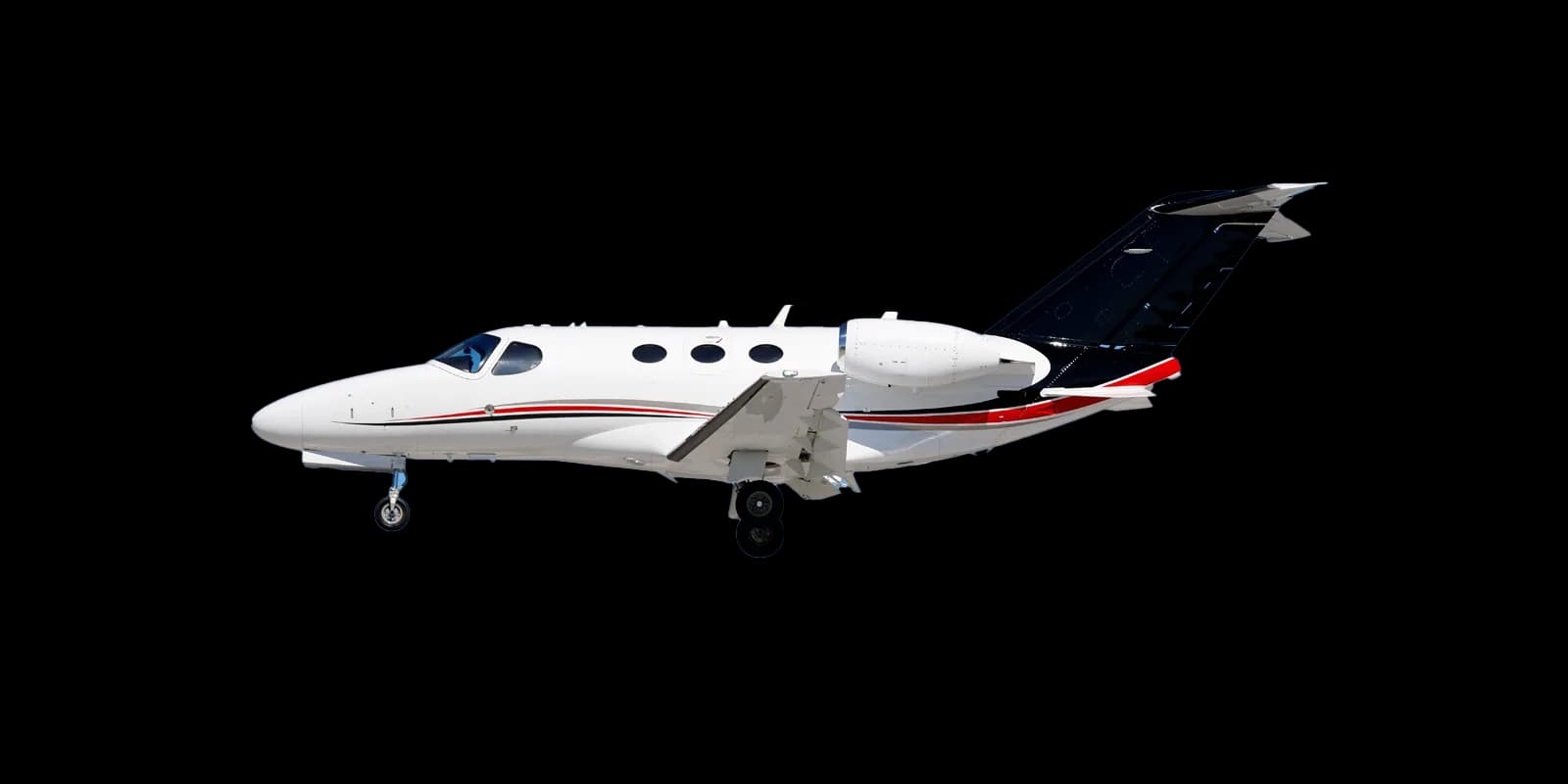 A white private jet with a black tail and red and grey stripes, seen from the side with landing gear extended against a blue sky.