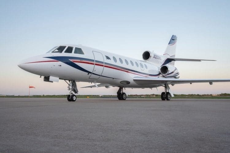 A Falcon 50 aircraft with registration N900KE is parked on the tarmac.