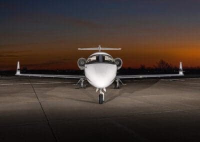 Front view of a Learjet 45XR aircraft parked on the tarmac at dusk.