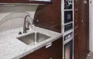A galley area with a sink, microwave, and oven.
