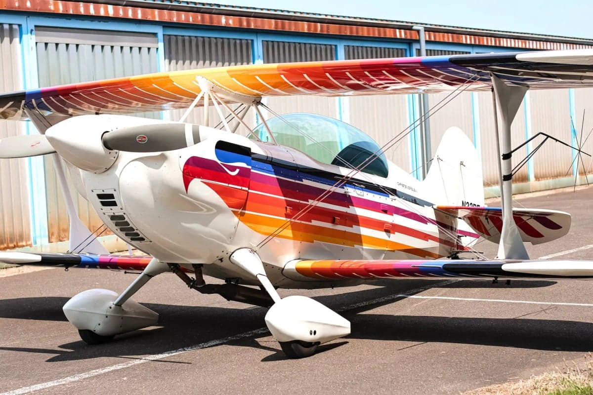 Close-up of the Christen Eagle II biplane showing the colorful paint scheme and registration N22BE.